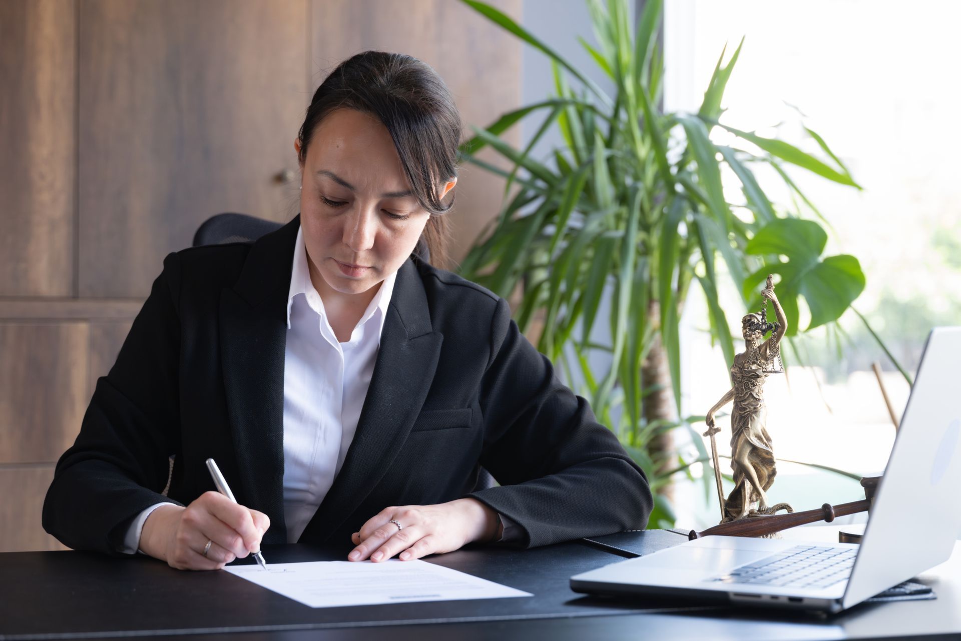 A legal advisor is signing a document. A legal advisor is signing a document.