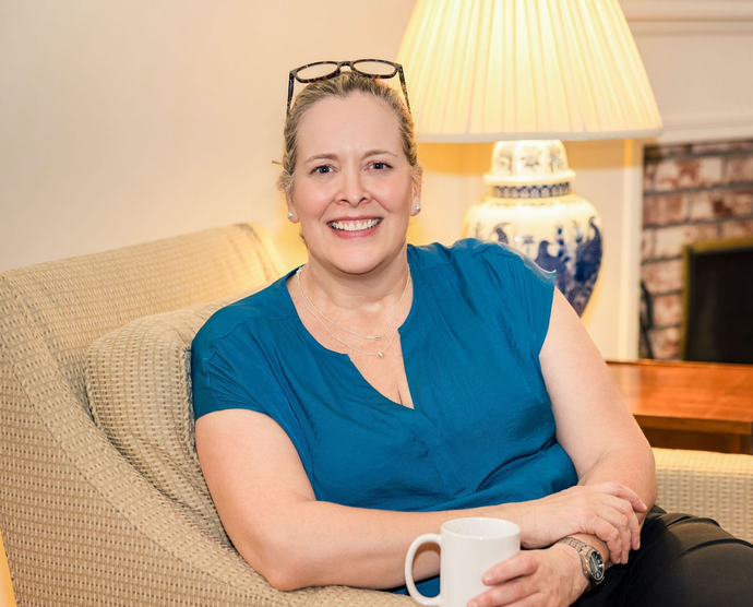 Joy Strickland, LMHC, seated in chair in Fayetteville, NY