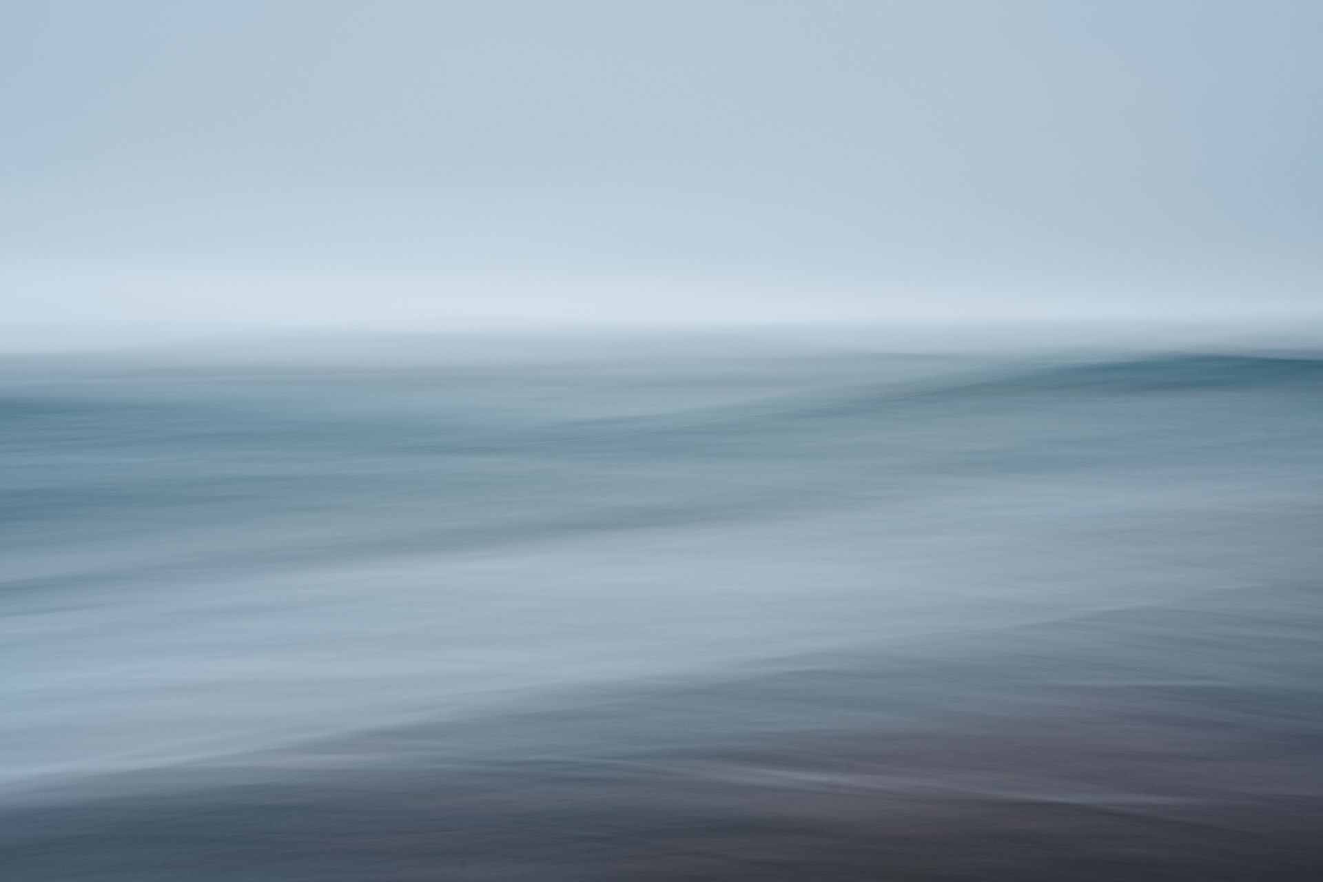 Soft blurred water and horizon in blue-gray tones