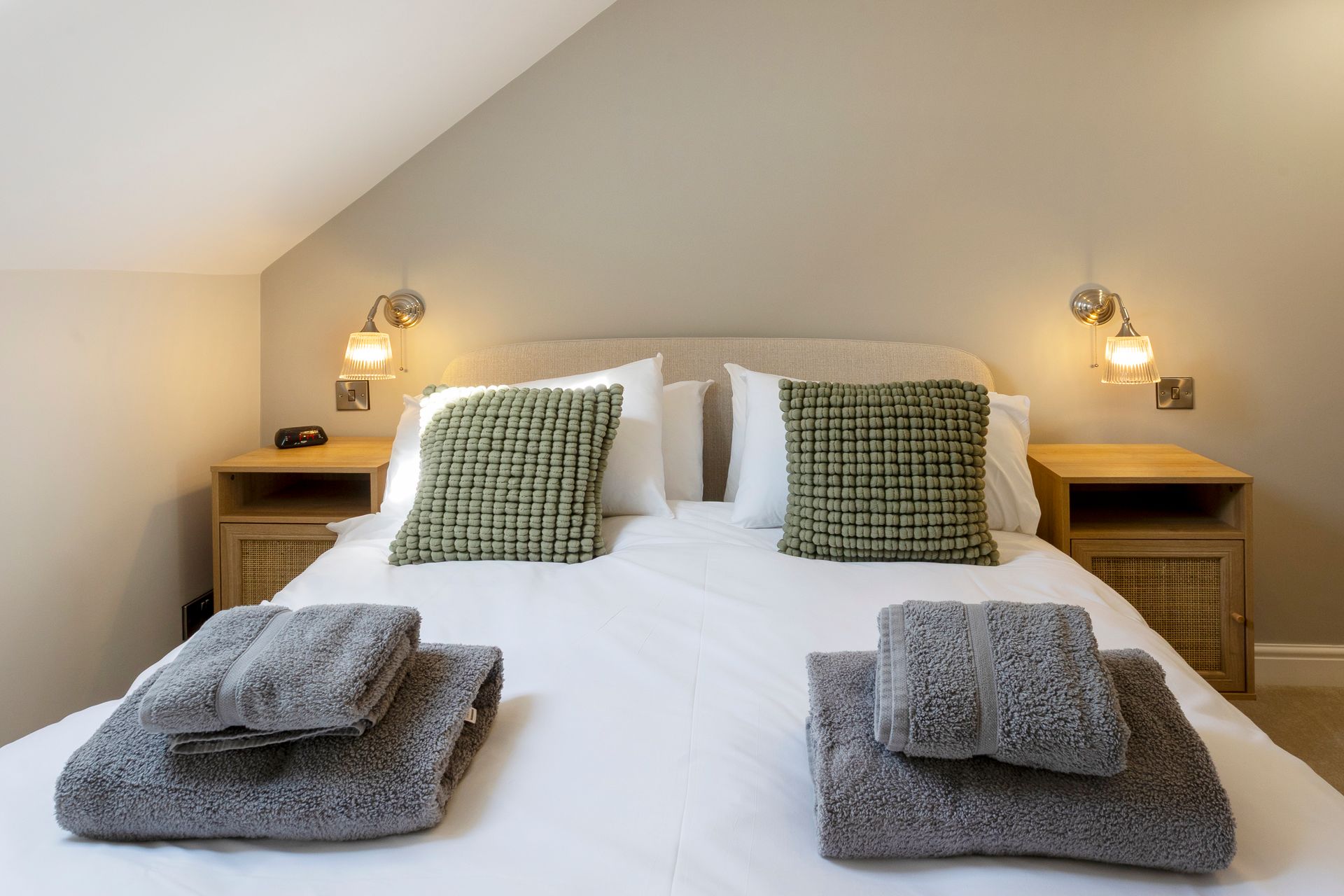 A bed with pillows and towels on it in a bedroom.