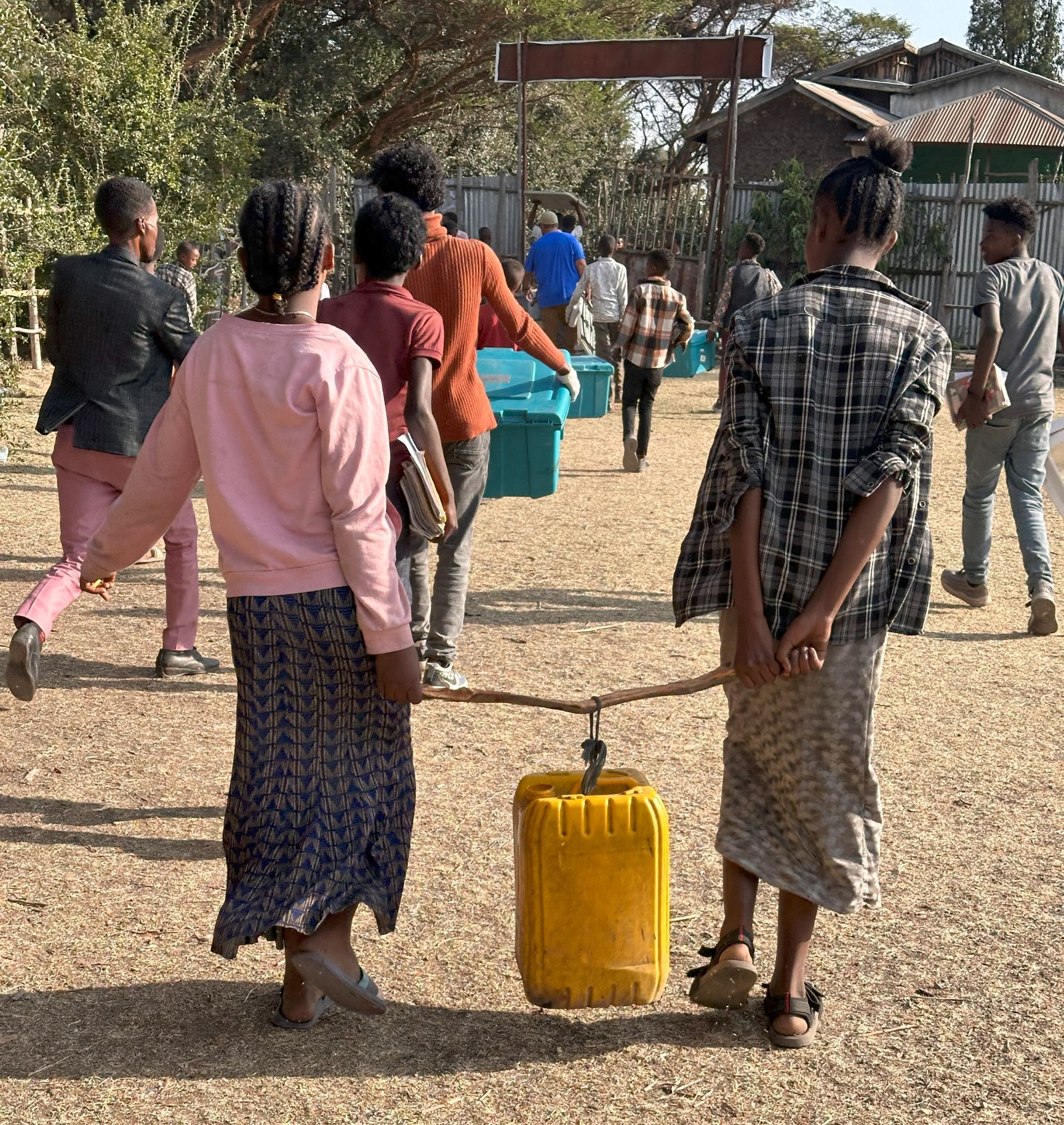 A group of people are standing around a yellow barrel