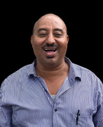 A man wearing a blue and white striped shirt is smiling for the camera.