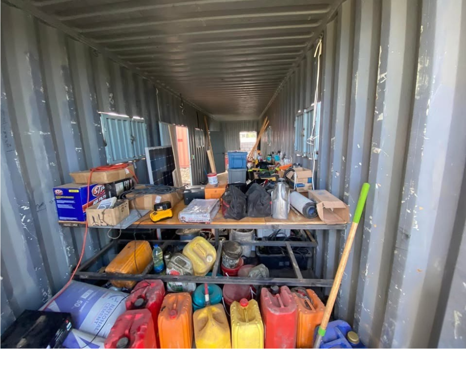 A container filled with lots of items including gas cans