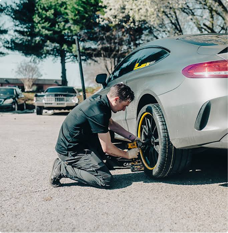 Changing a rear tire outdoors. | Hangar Unlimited Auto Care & Tires
