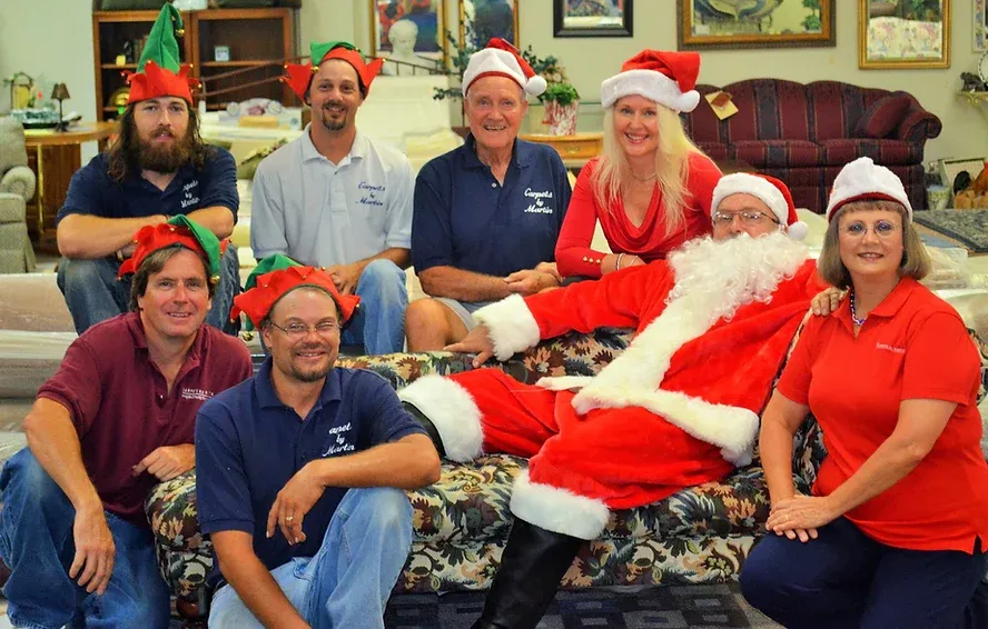 A group of people posing for a picture with santa claus