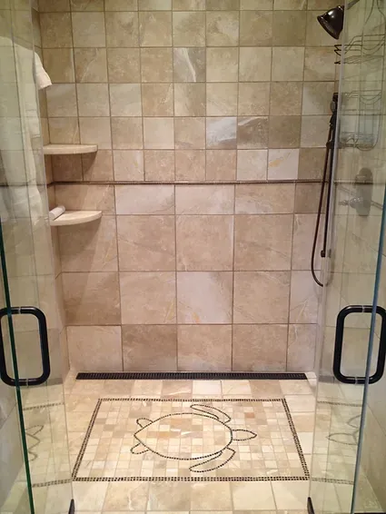 A walk in shower with a turtle design on the floor