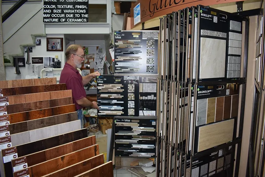 A man standing in front of a display of tiles and wood
