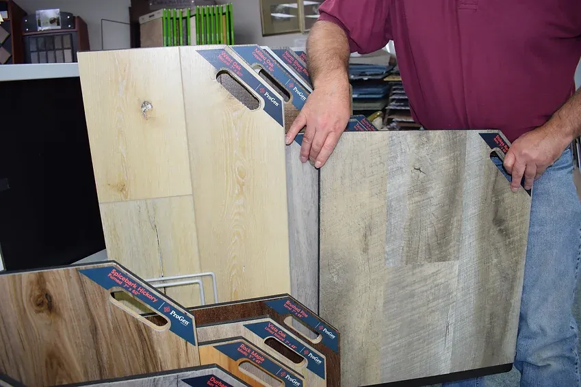 A man is holding a piece of wood in his hands.
