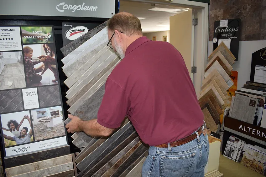 A man is looking at a display of tiles in a store.