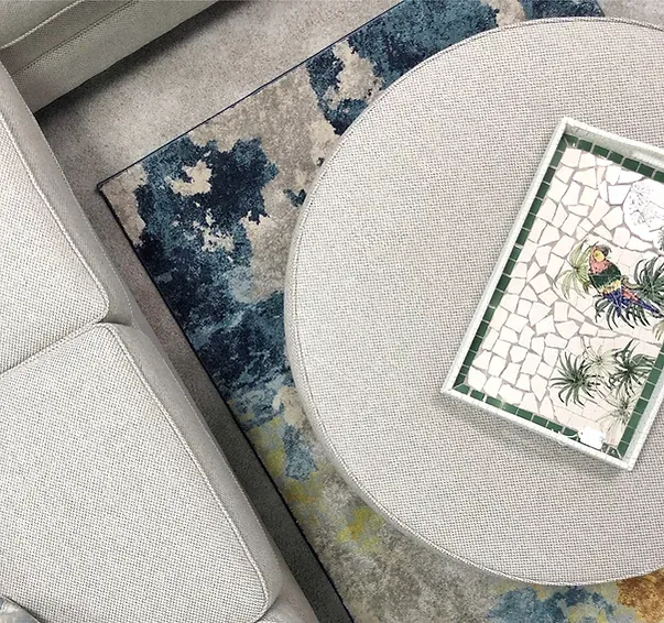 A round coffee table with a tray on top of it in a living room.