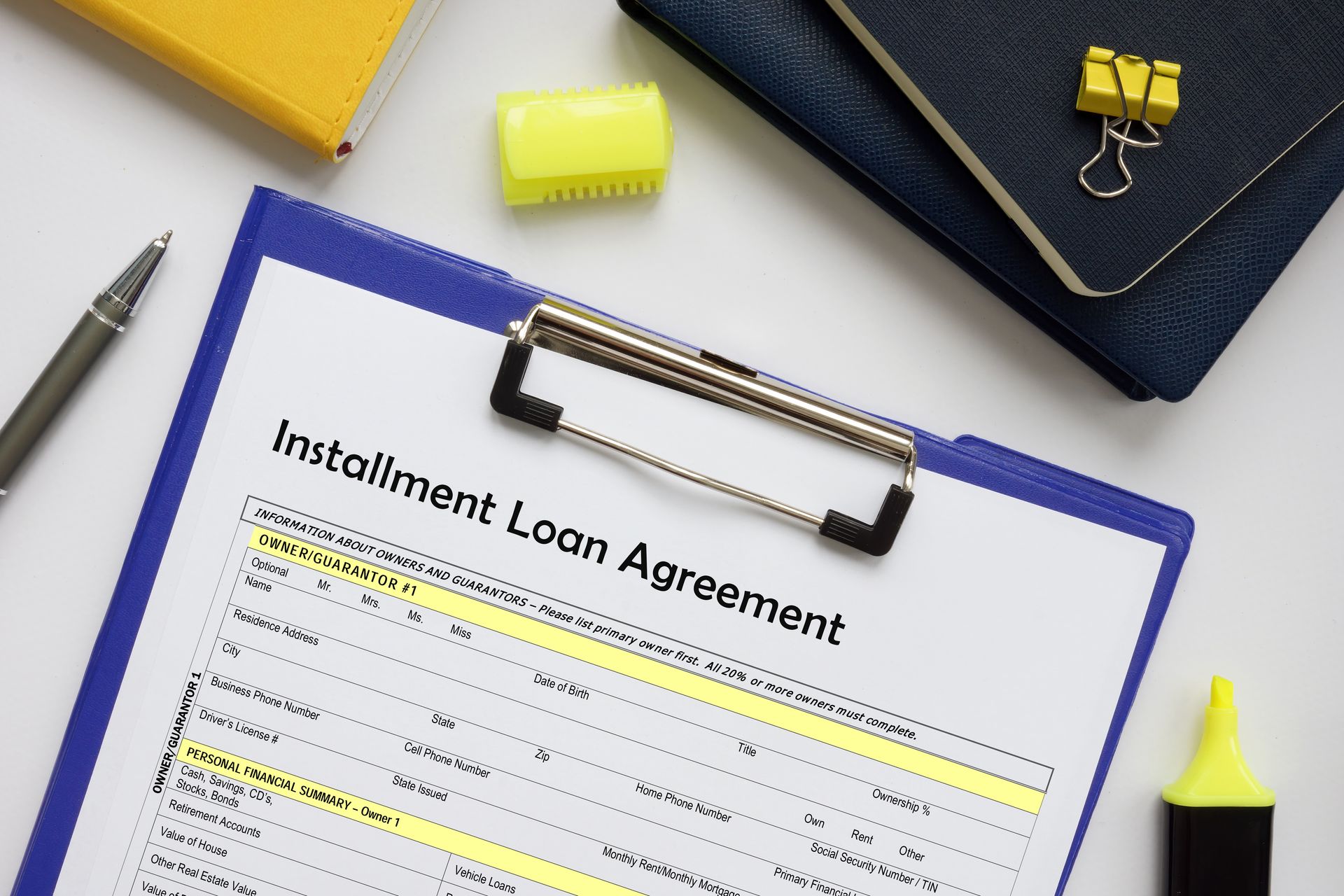 Installment loan agreement on clipboard with financial documents. Installment loan agreement on clipboard with financial documents.