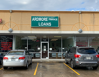 Storefront of Ardmore Finance Loans with parked cars in front on a rainy day
