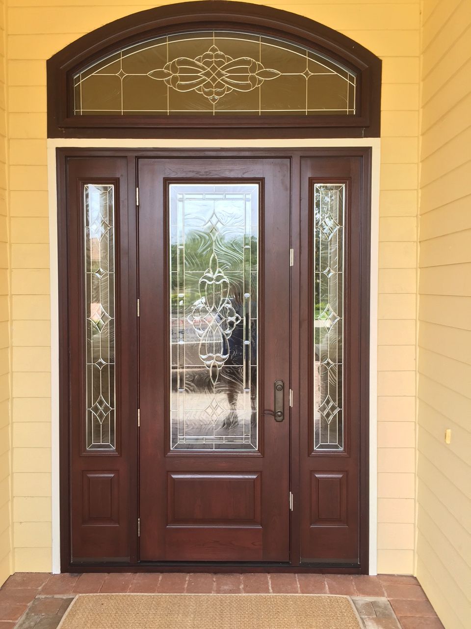 A large wooden door with a stained glass window