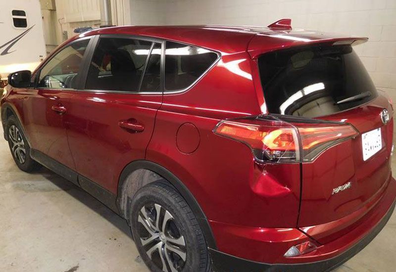 A red toyota rav4 is parked in a garage.