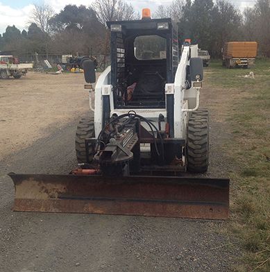 A small bulldozer is parked on the side of the road.