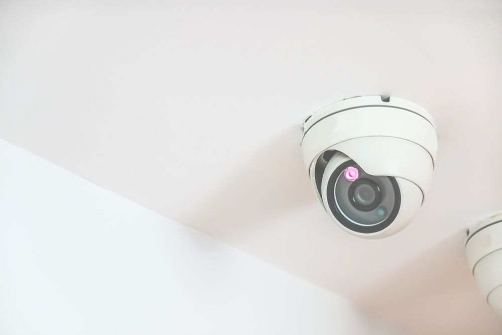 Two Security Cameras Are Hanging From the Ceiling of a Building — Hendo's TV Antennas & Installations in Innisfail, QLD