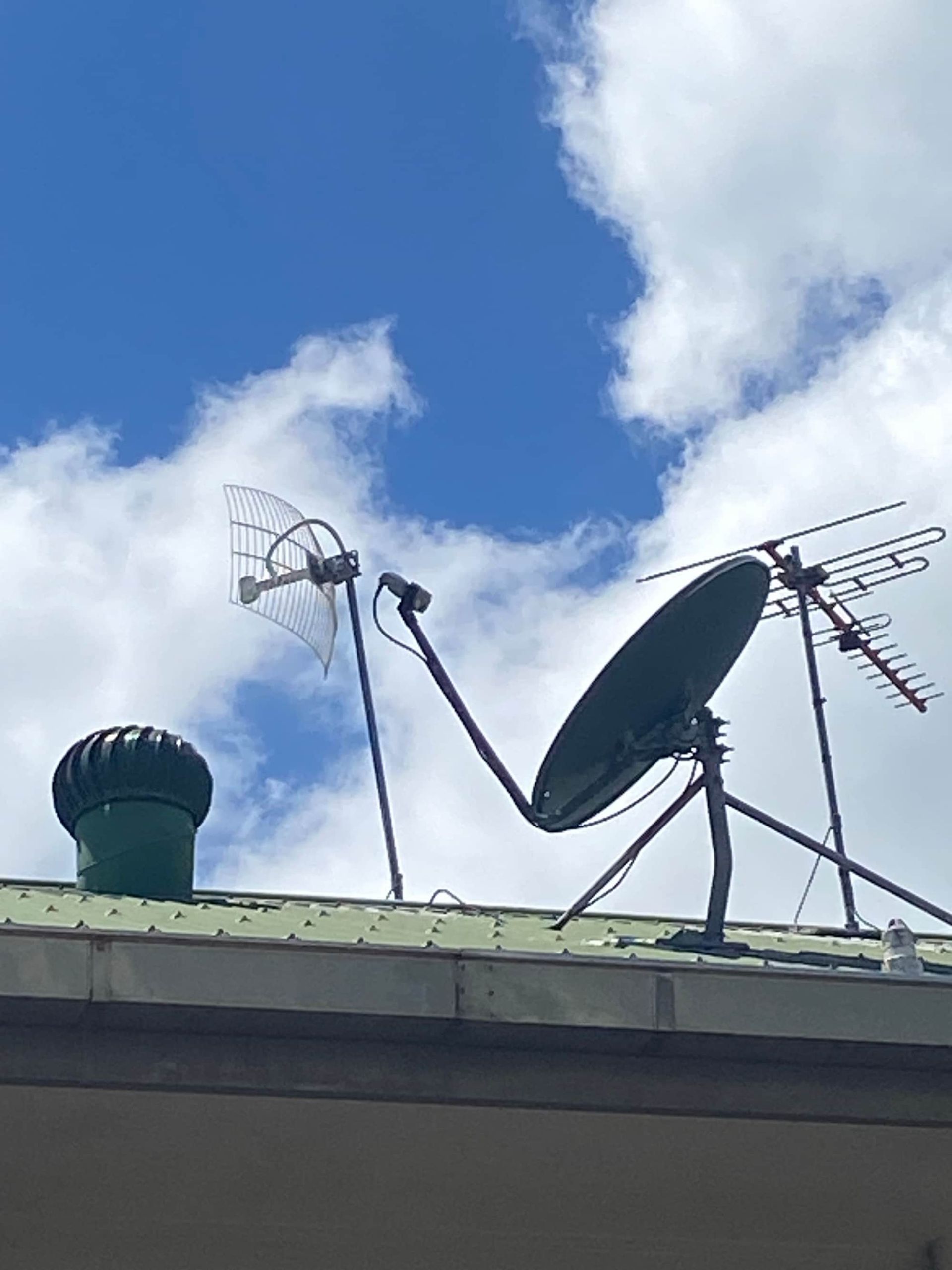 A Satellite Dish is Sitting on Top of a Green Roof — Hendo's TV Antennas & Installations in Tablelands, QLD
