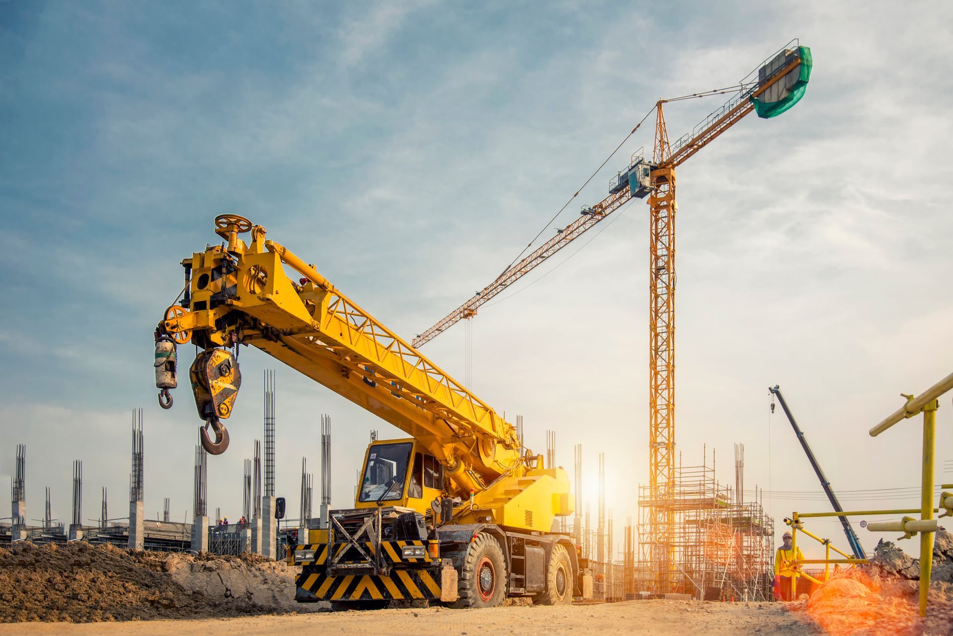 A yellow construction crane at a site, highlighting crane services and ongoing building projects.