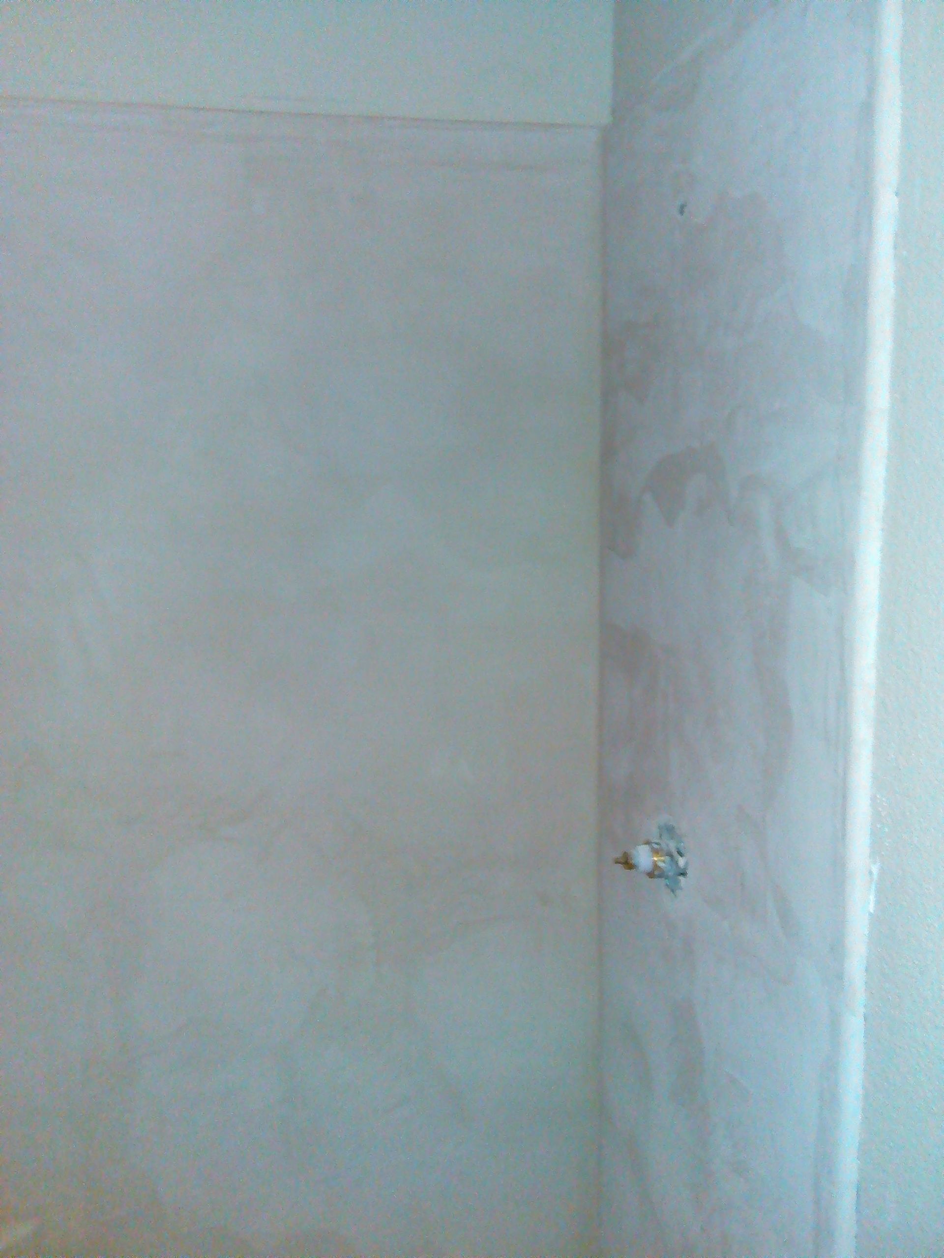 Close-up of a worker's hand carefully applying gypsum plaster to ceiling joints, creating a smooth and seamless finish.