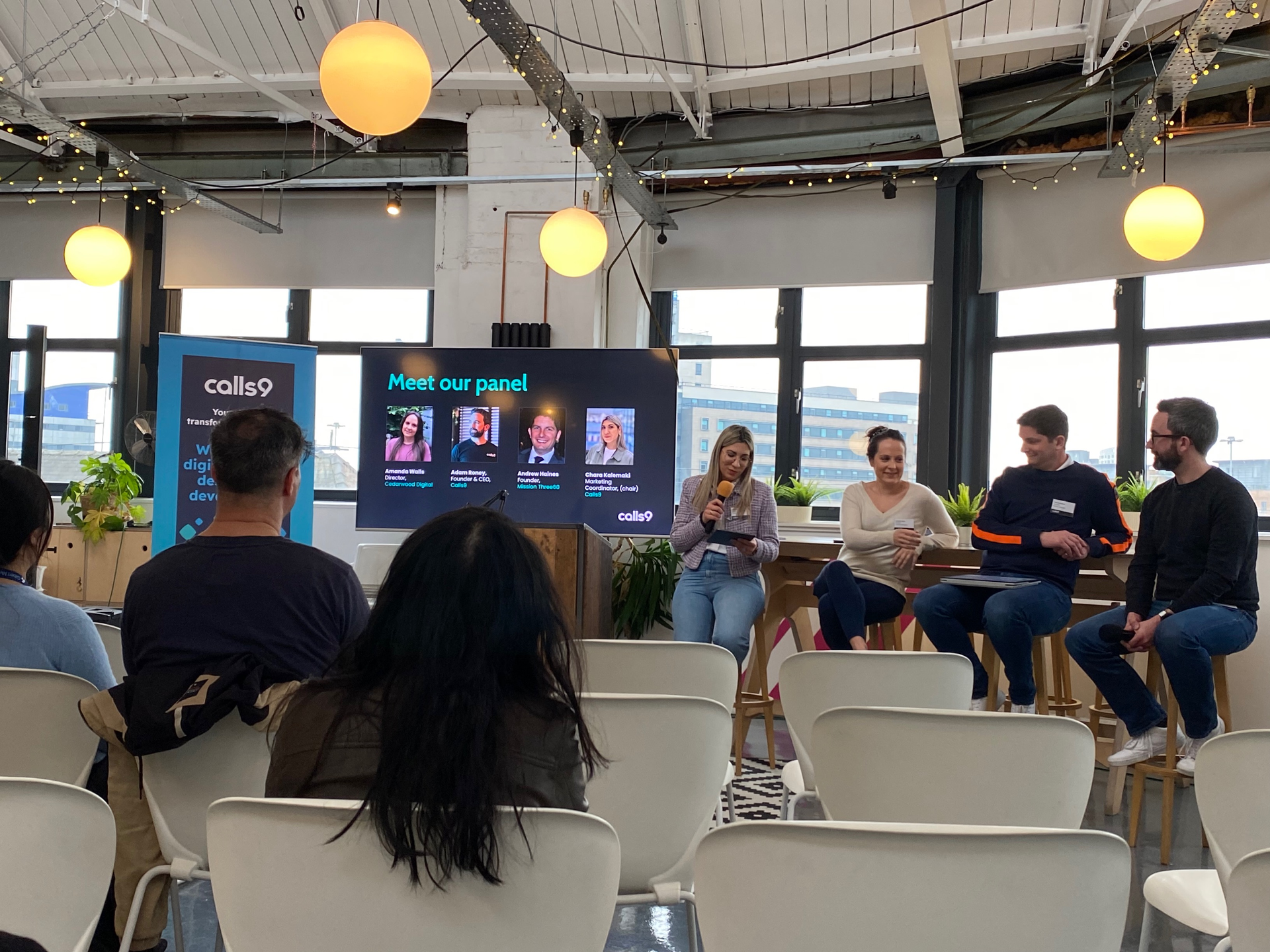 A group of people are sitting in chairs watching a presentation.