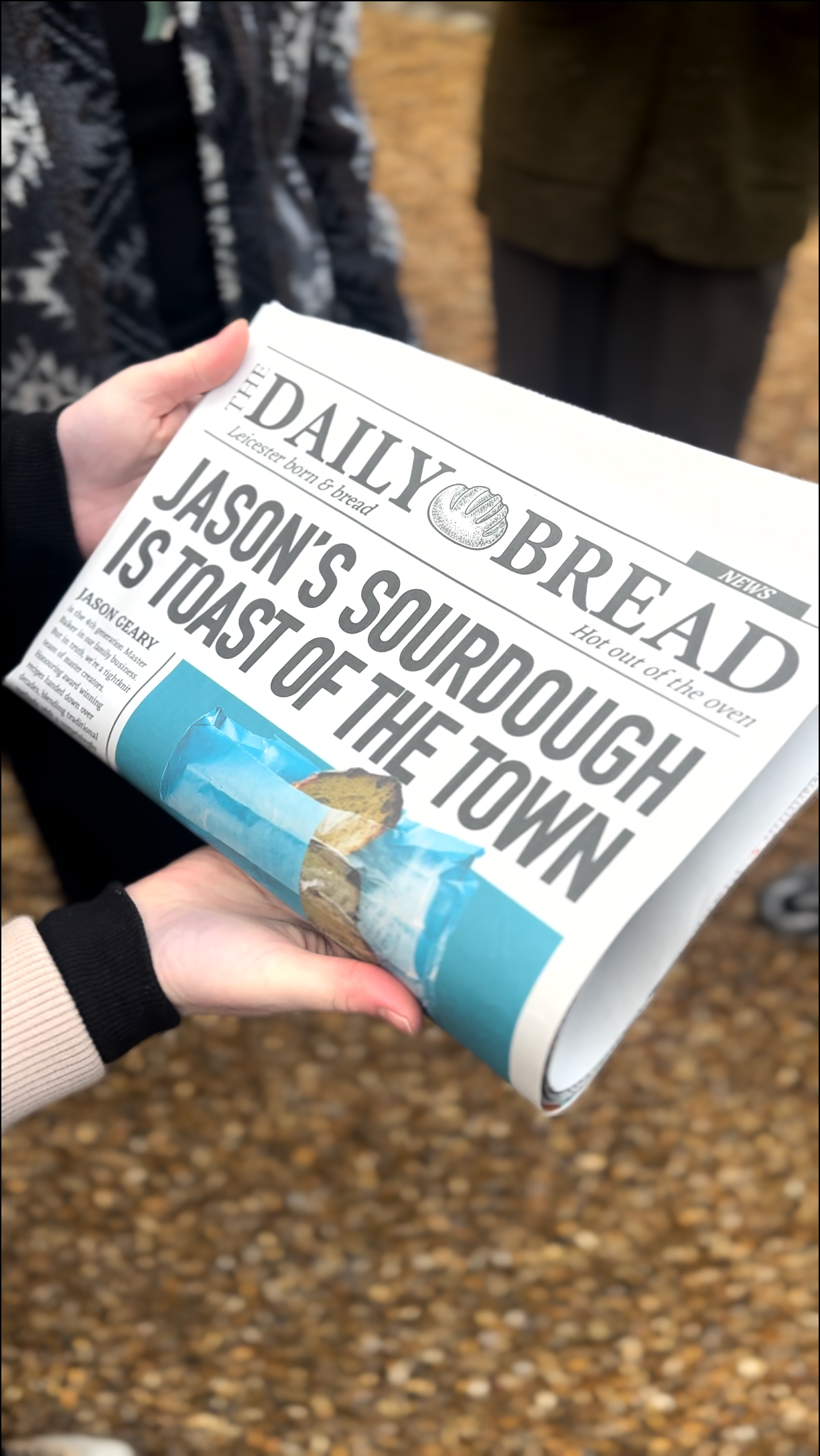 Person holding a newspaper with headline: