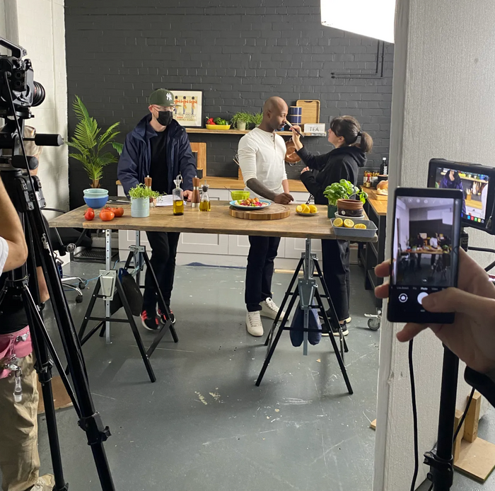 A person is taking a picture of a man in a kitchen