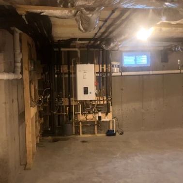 Basement with exposed pipes, water heater, and unfinished walls.