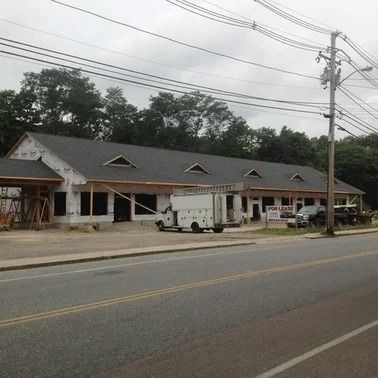 Building under construction with dark roof, windows, and 