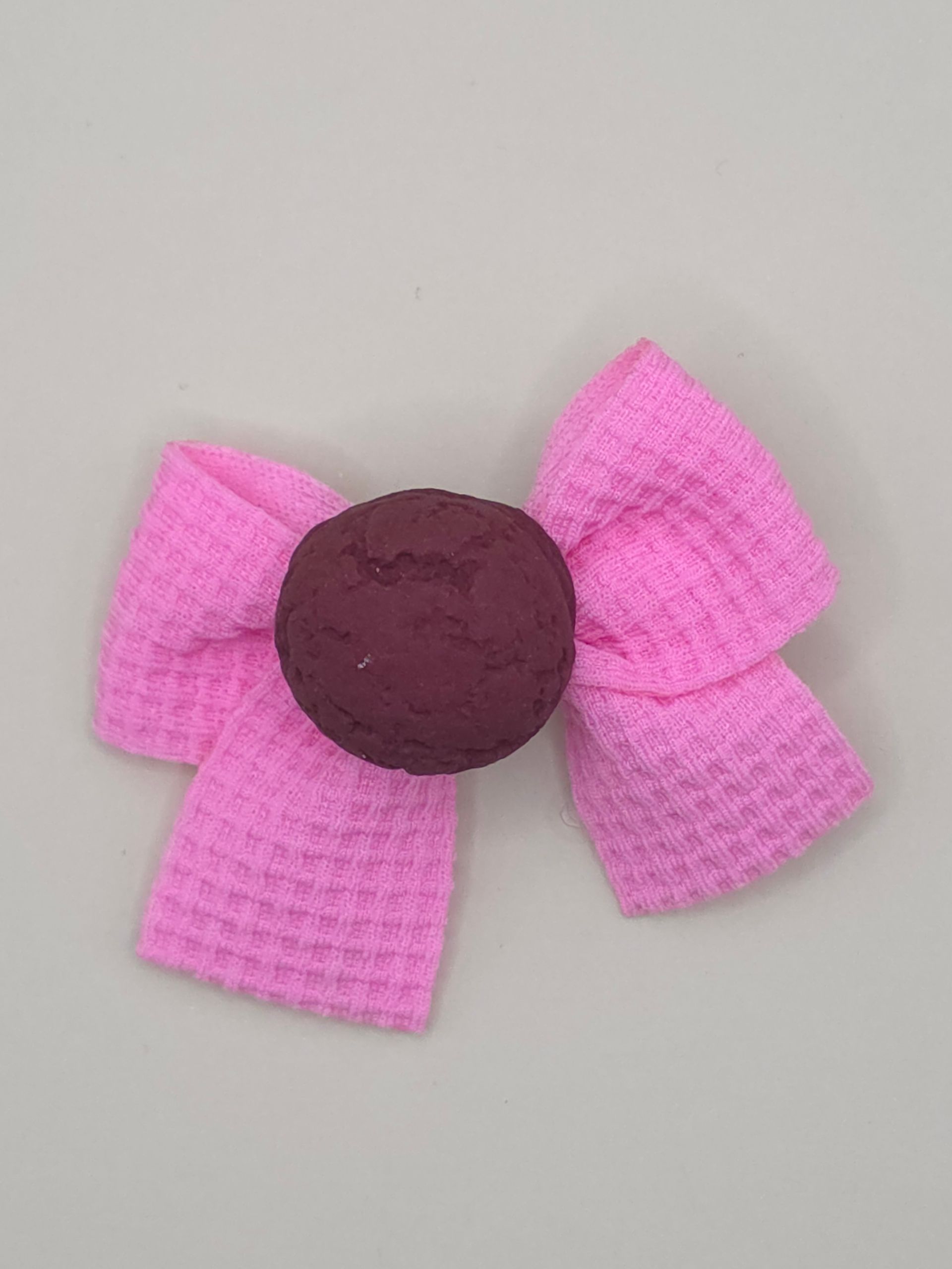 Verspreid rood brokjesmateriaal en kleurrijke hartvormige snoepjes rond een roze hart met een bruin midden.