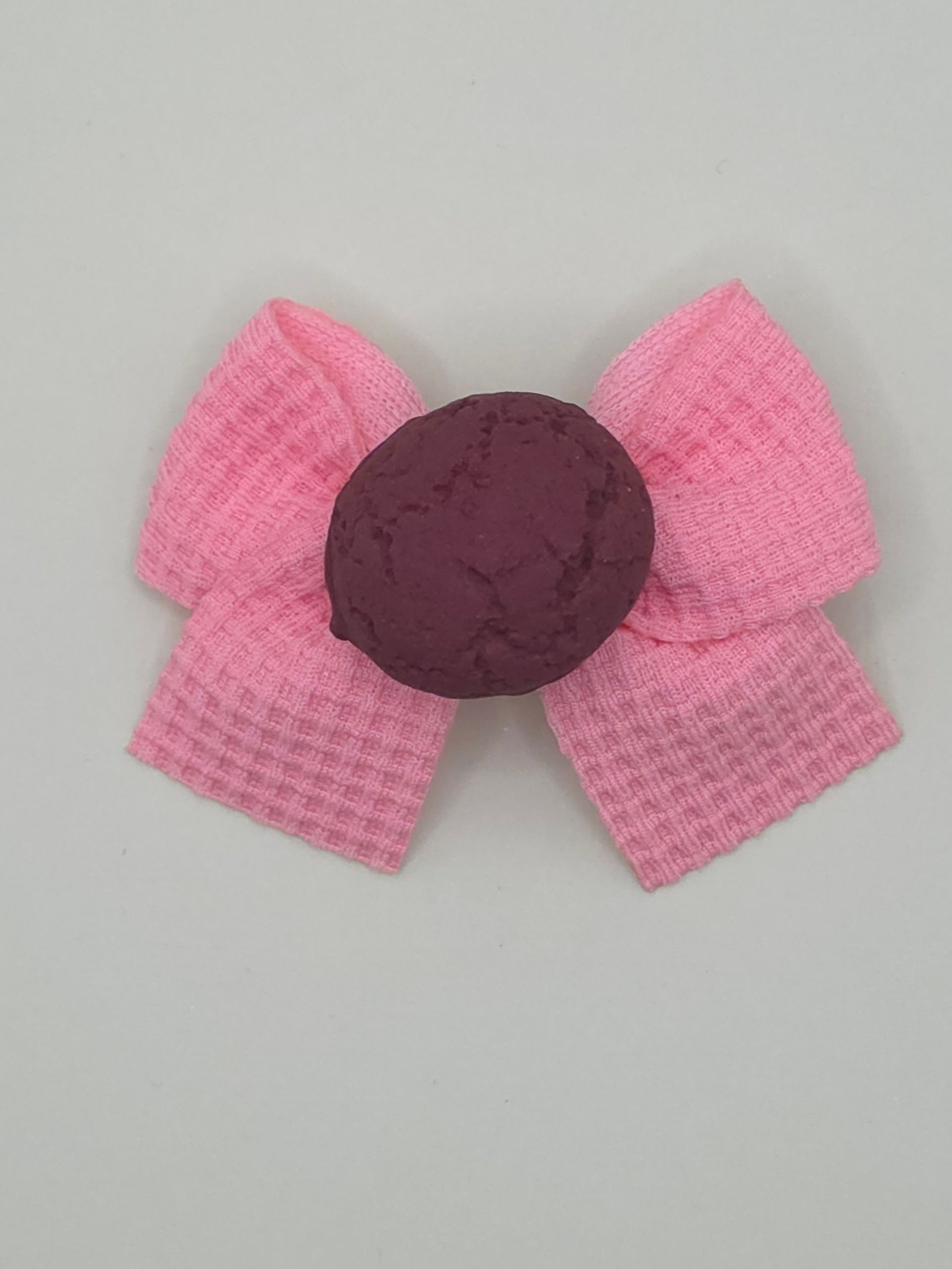 Diverse roze en bruine snoepjes gerangschikt in een hartvormige cirkel op een lichte achtergrond.