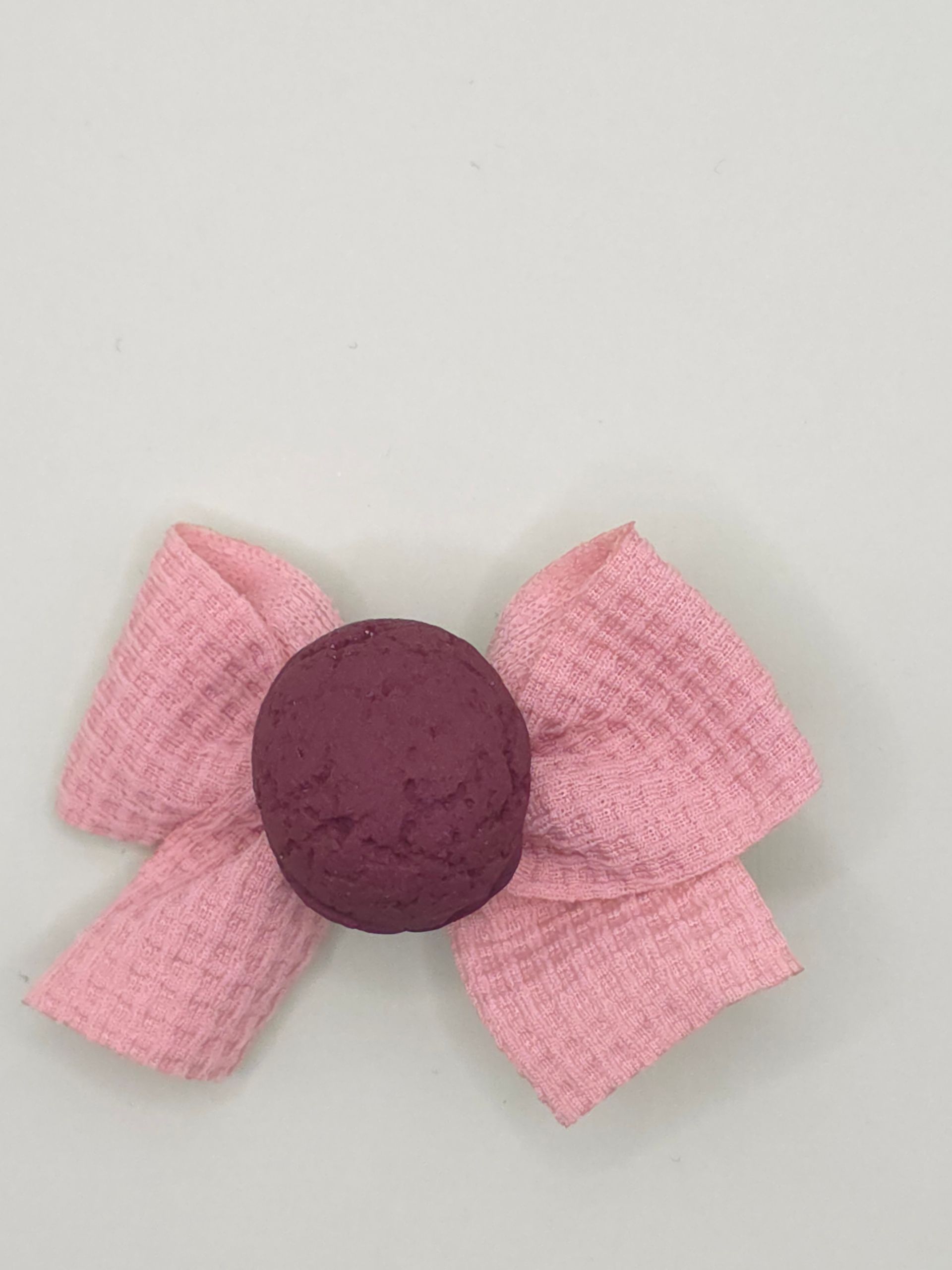 Hartvormige snoep- en koekjesschikking met roze, paarse en bruine snoepjes op een lichte ondergrond.