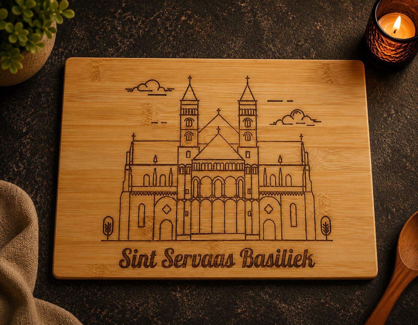 Lasergegraveerd houten bord met een afbeelding van een kathedraal op een donkere tafel met kaarsen en planten als decoratie.