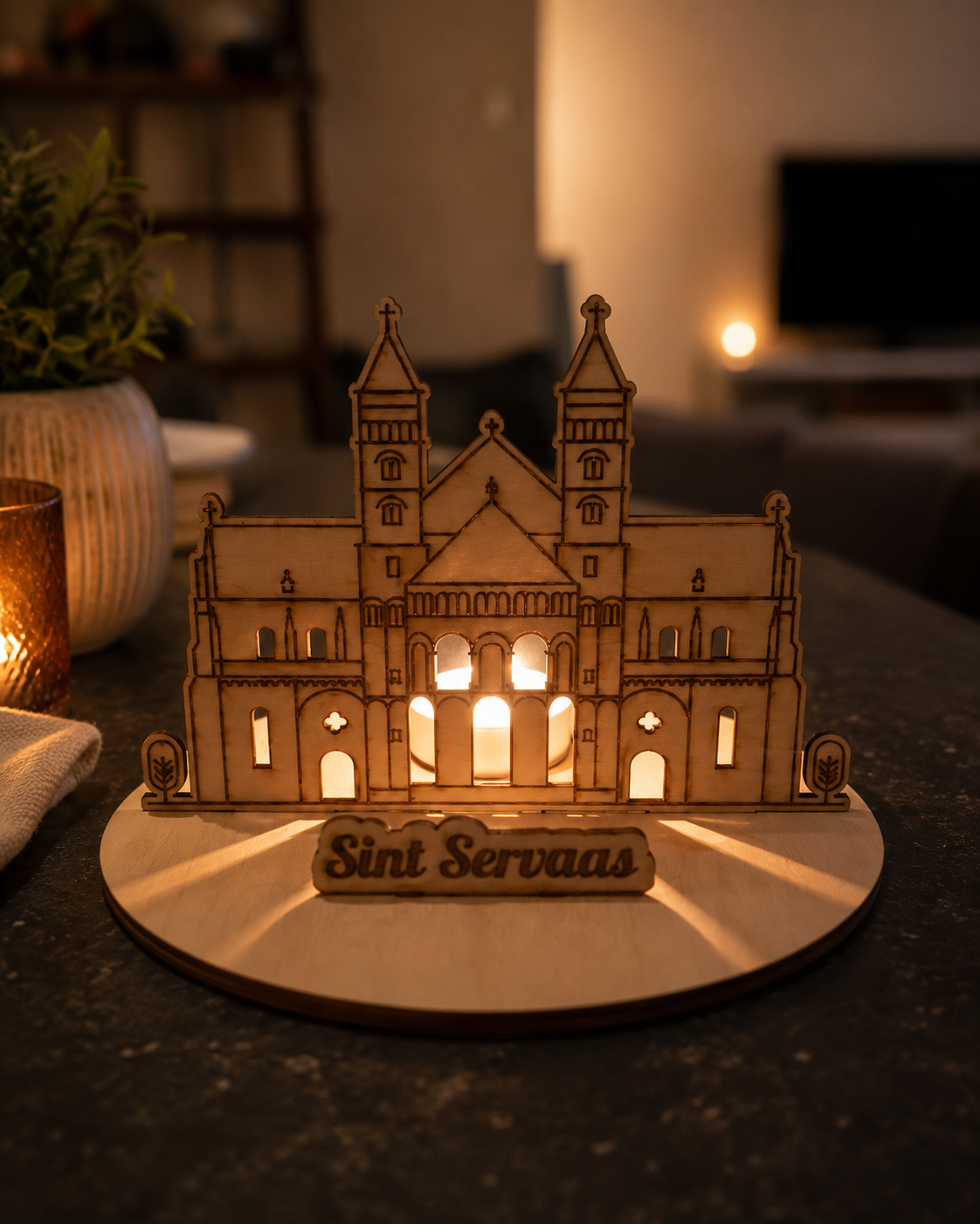Een houten model van een kathedraal, sfeervol verlicht door warme lampen, staat als middelpunt op een eettafel