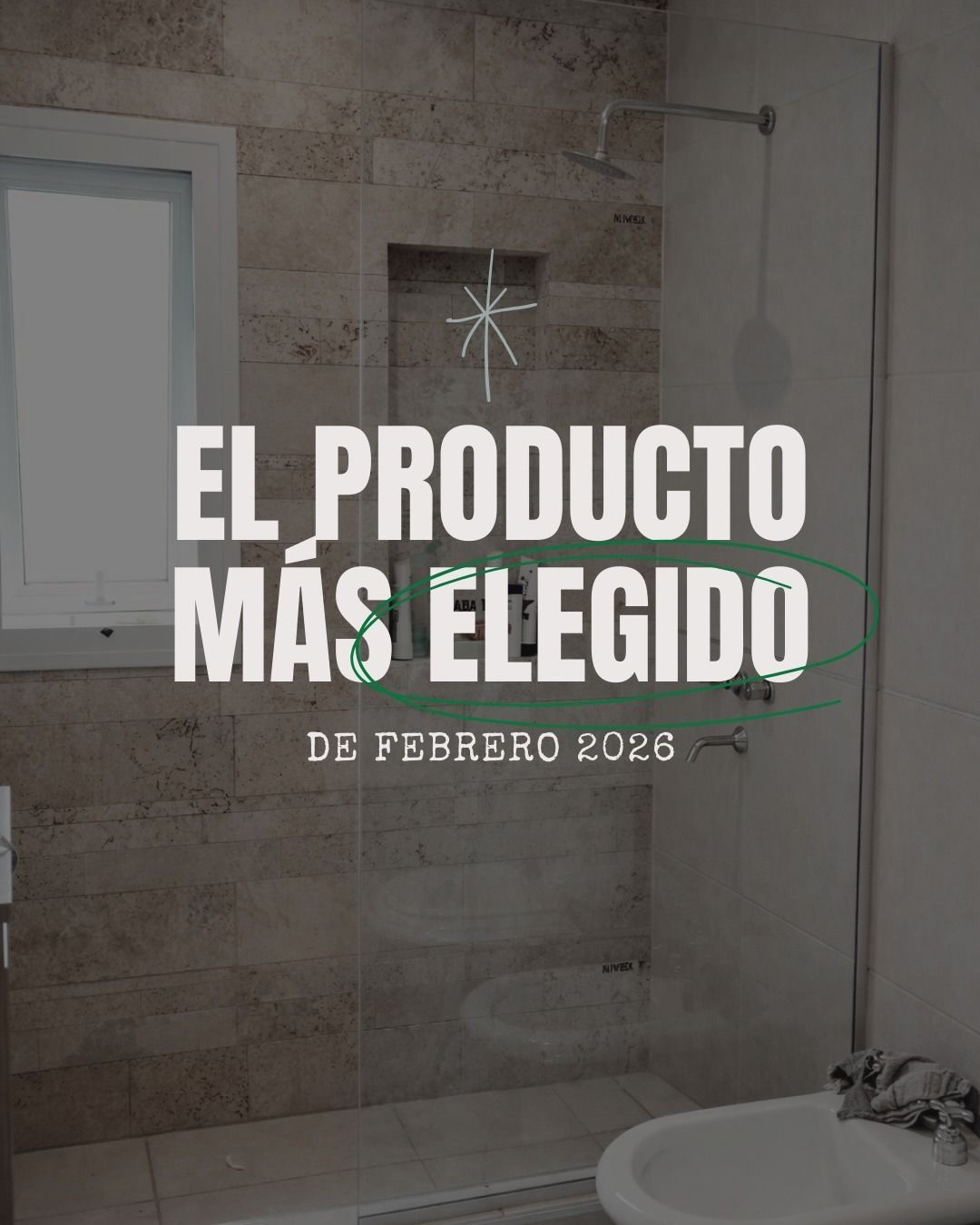 Baño moderno con texto promocional “EL PRODUCTO MÁS ELEGIDO DE FEBRERO 2026” sobre una ducha de vidrio