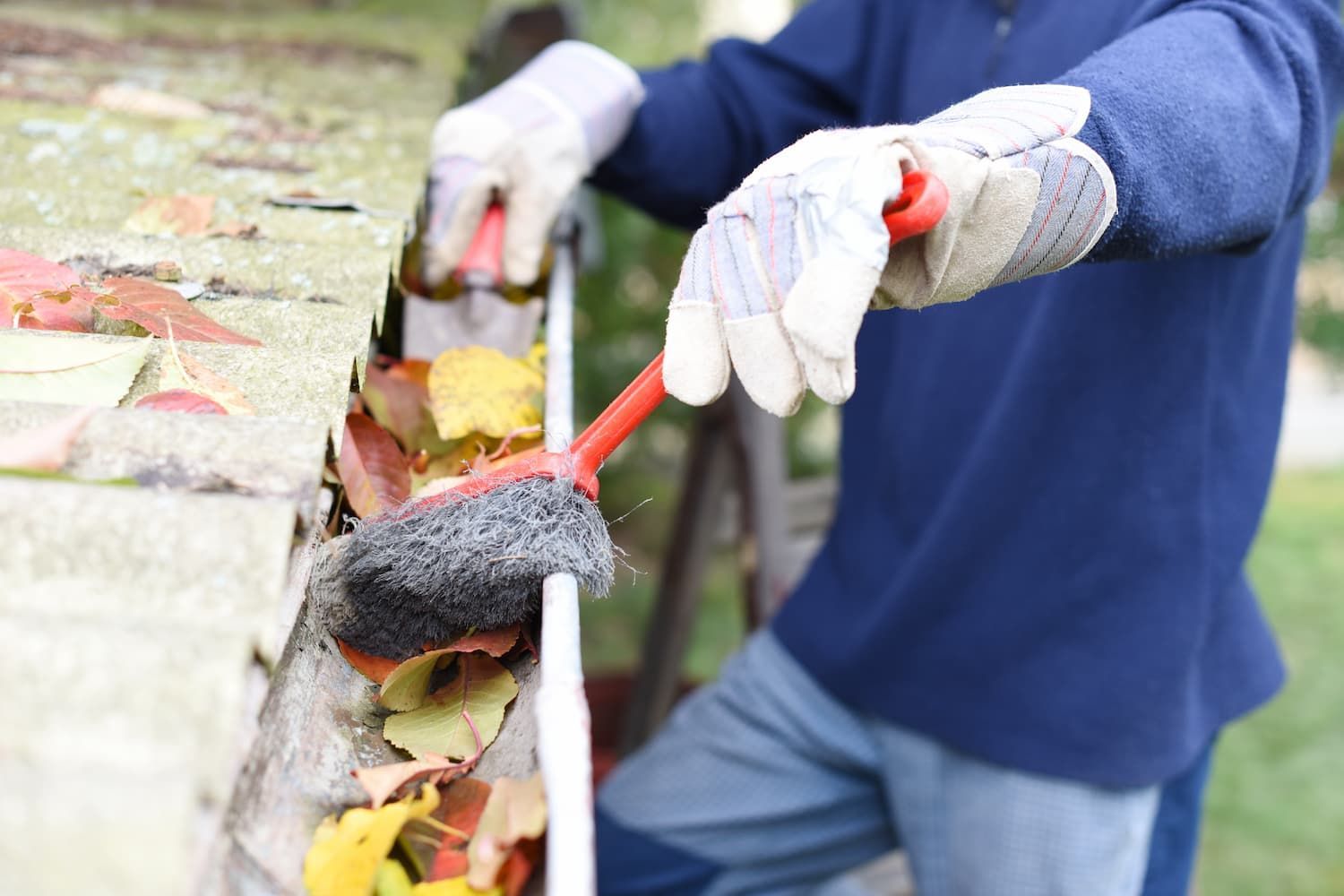 A Person is Cleaning a Gutter With a Brush — TK Guttercleaning in Terrigal, NSW