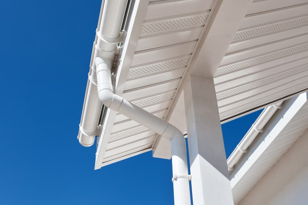 A White Gutter on the Roof of a House With a Blue Sky in the Background — TK Guttercleaning in Gosford, NSW