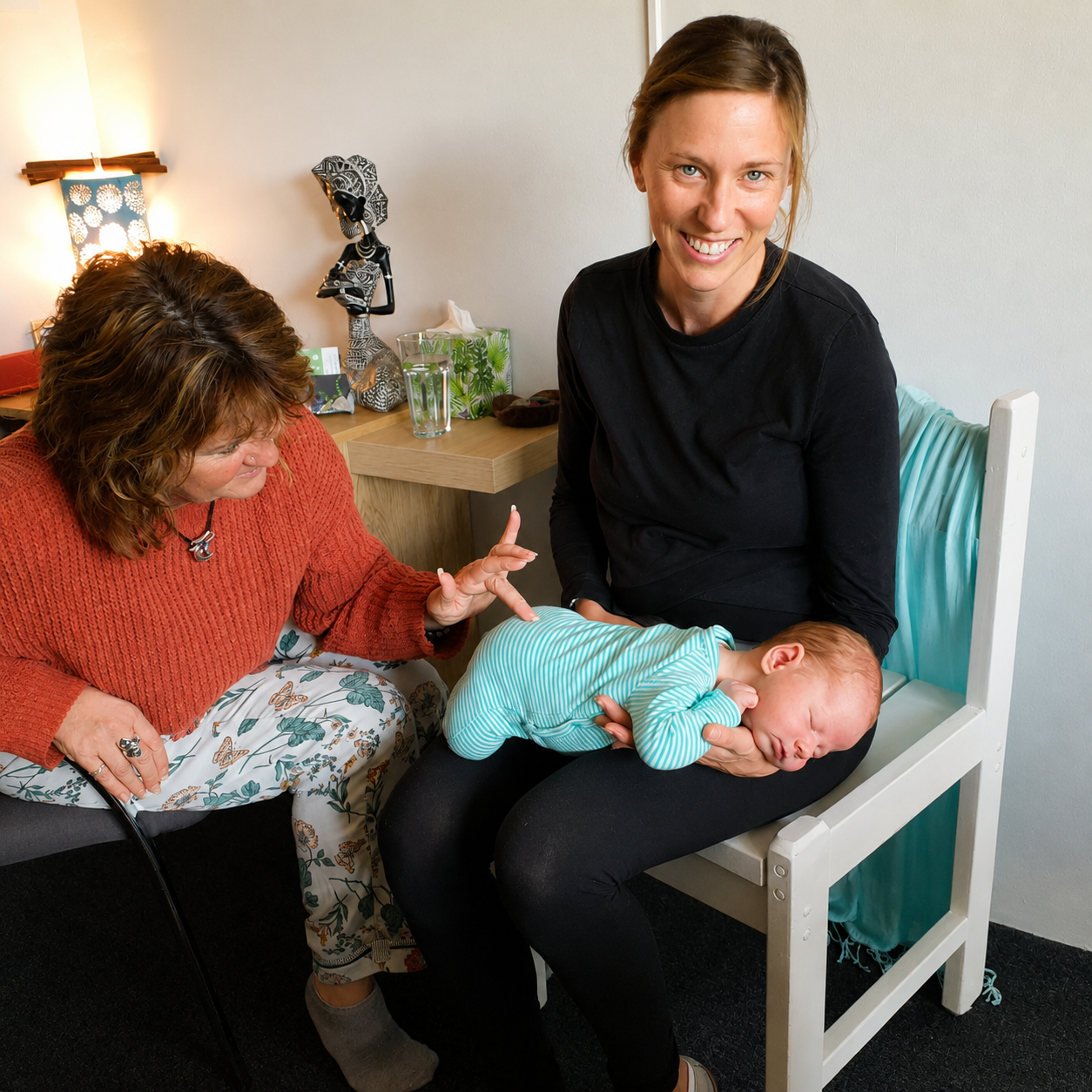 Tina, Spinal Flow practitioner at Akiki Spinal Flow, Sunshine Coast QLD. Two women with a sleeping baby on one’s lap in a cozy room