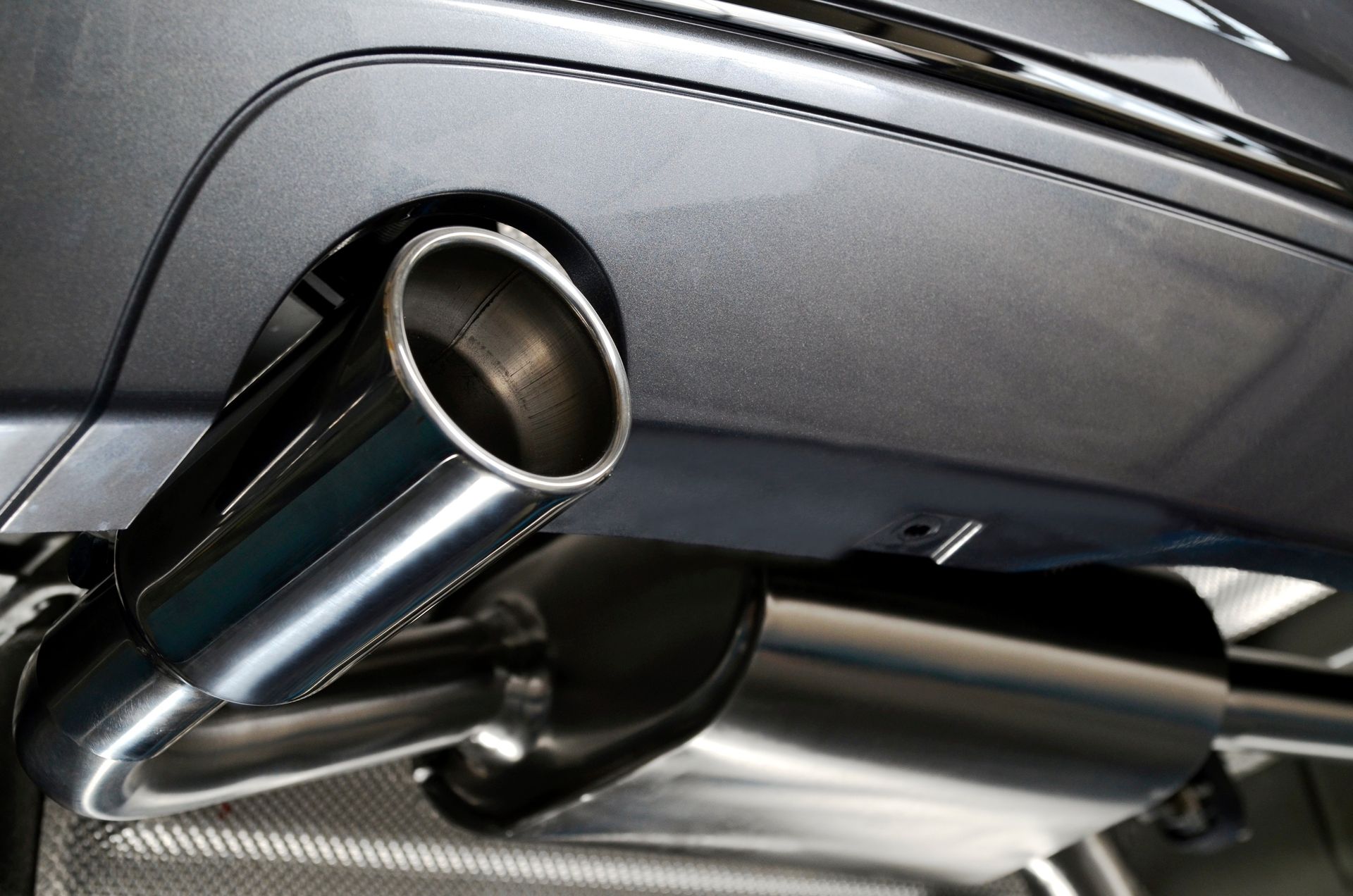 Close-up of a chrome car exhaust pipe beneath a vehicle