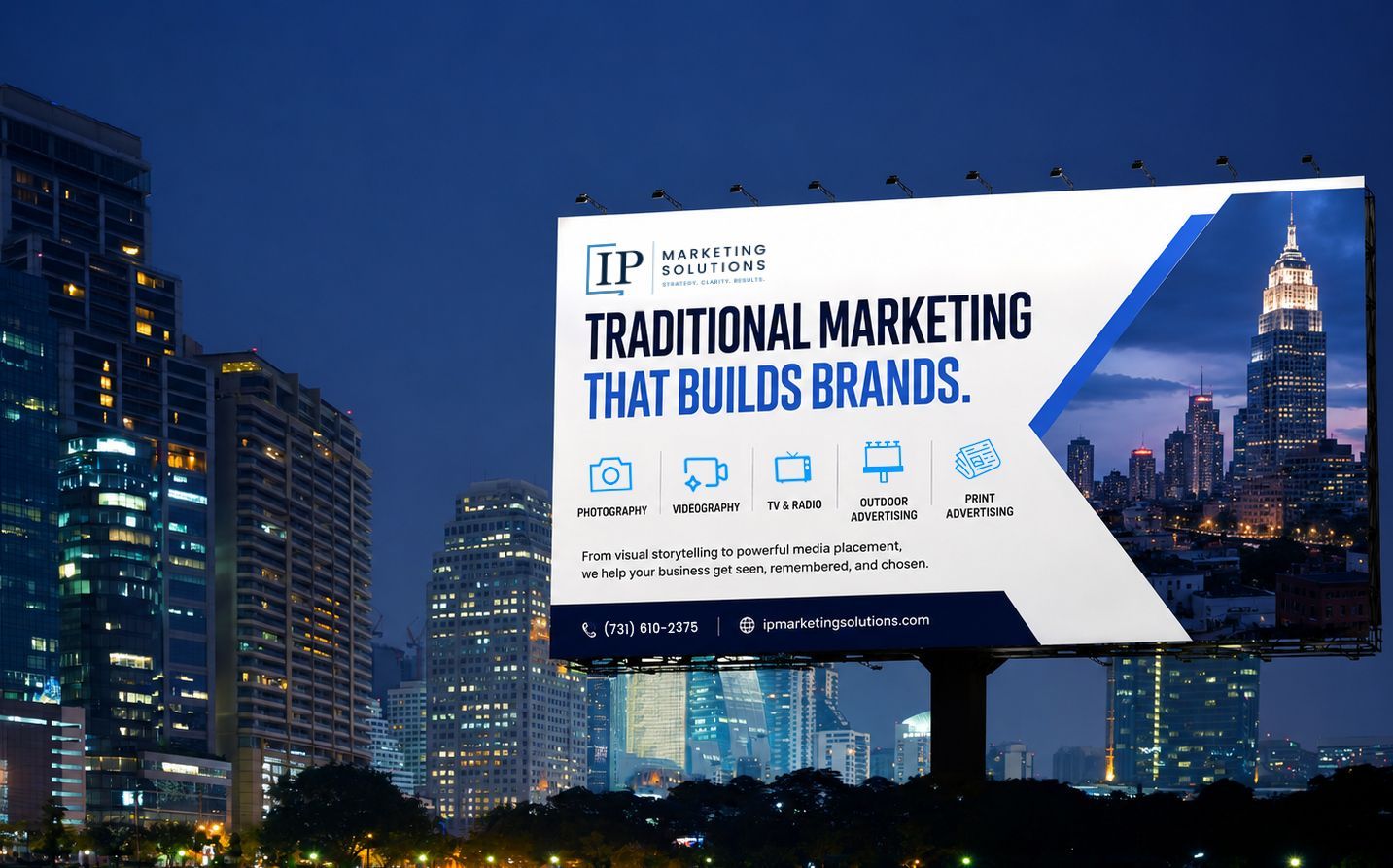 Billboard ad at night over a city skyline, reading “Traditional marketing that builds brands.”