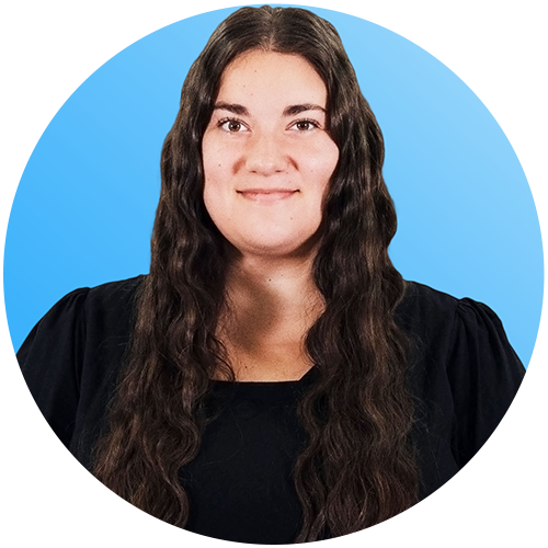 Portrait of a smiling person with long dark hair against a blue background