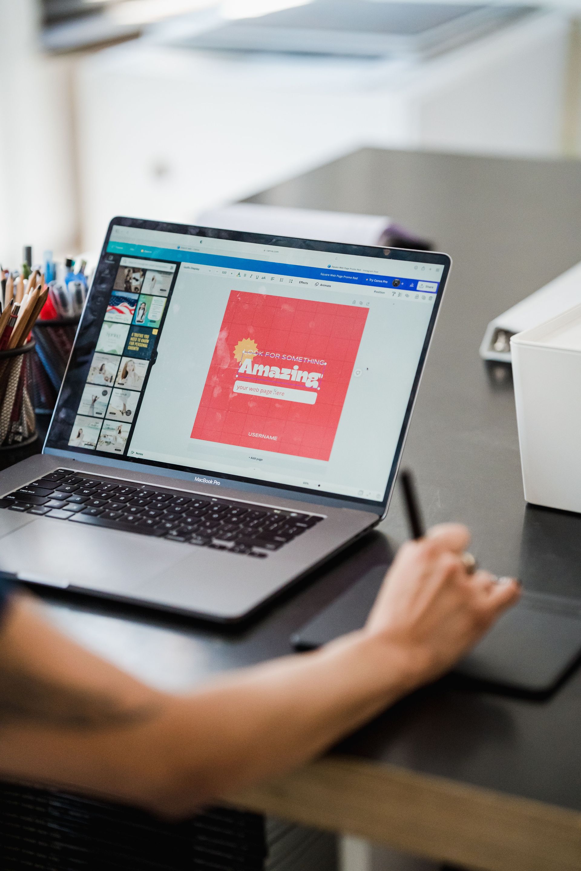 Person using a laptop at a desk, editing a colorful presentation on screen
