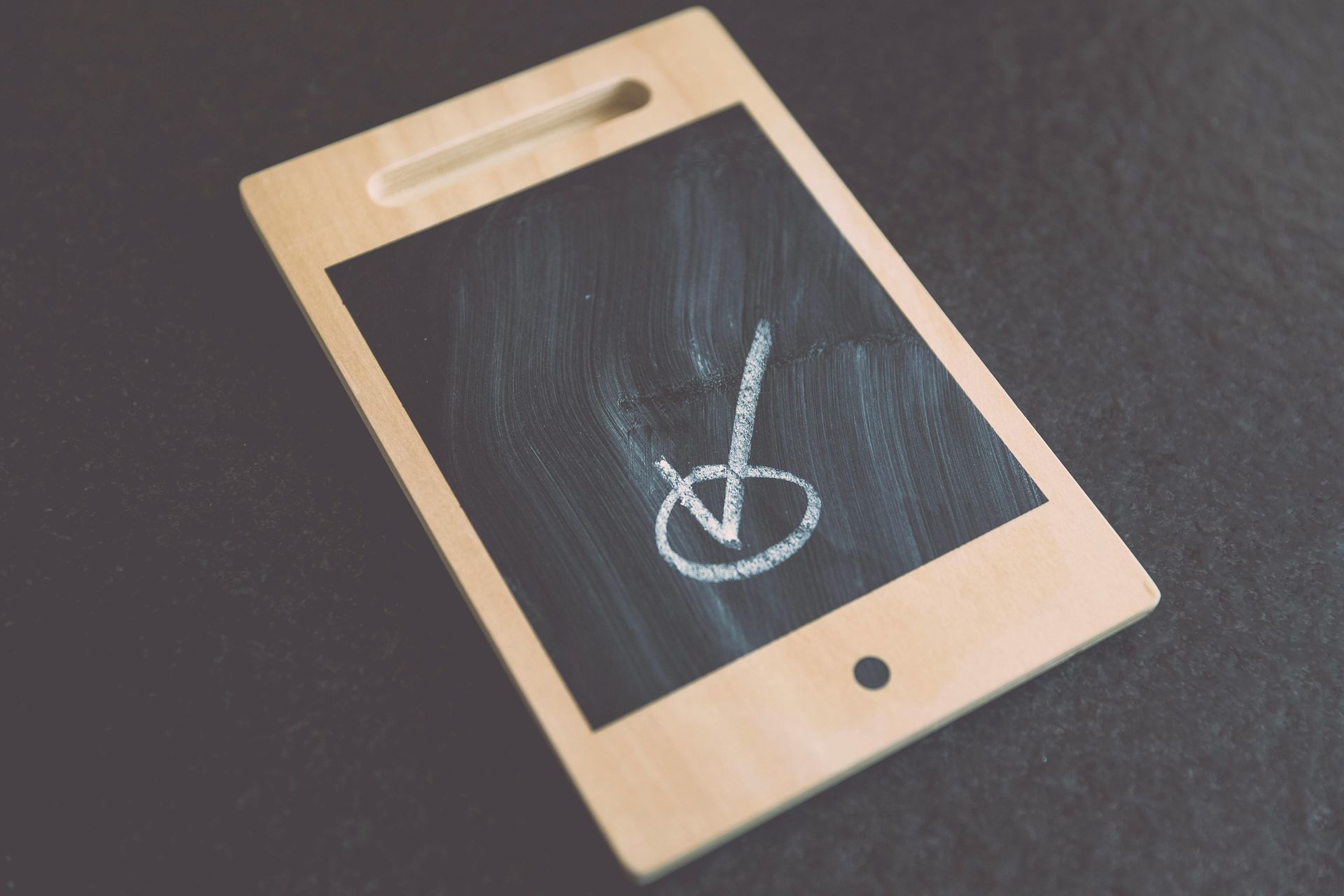 Wooden touchscreen panel with chalk arrow and circle on black screen