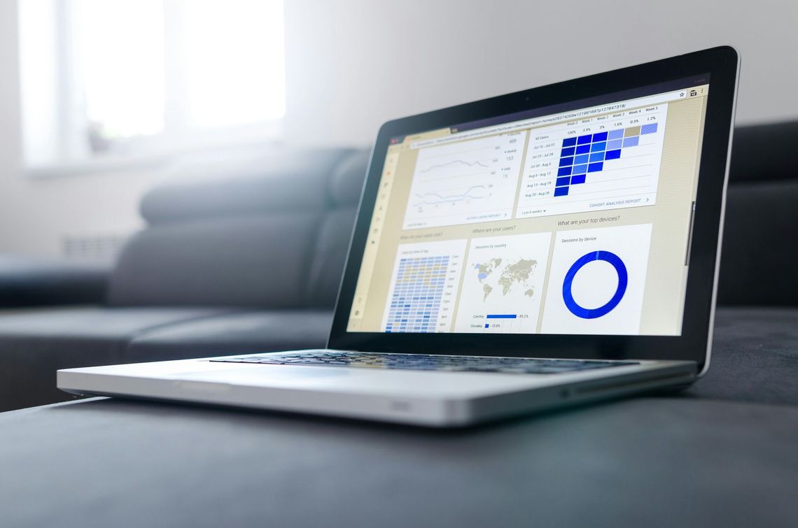 Laptop displaying analytics charts on a desk in a bright office setting