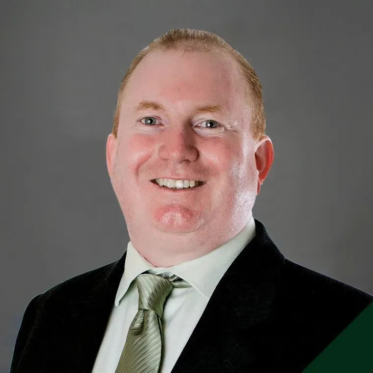 A man in a suit and tie is smiling for the camera.