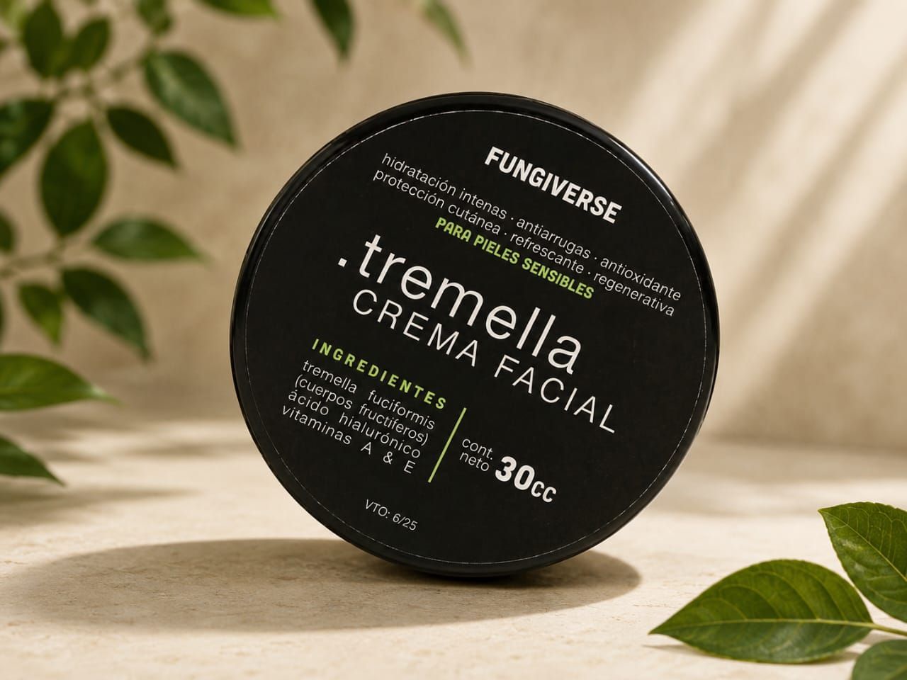 Tarro redondo negro de crema facial Tremella Crema con hojas verdes sobre una superficie beige.