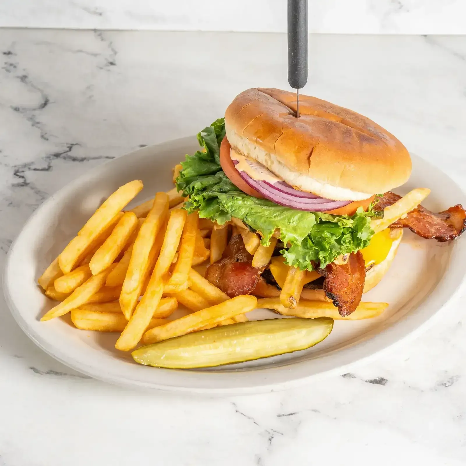 Classic burger with bacon, lettuce, onion, and fries at Hollywood Family Café in Lodi