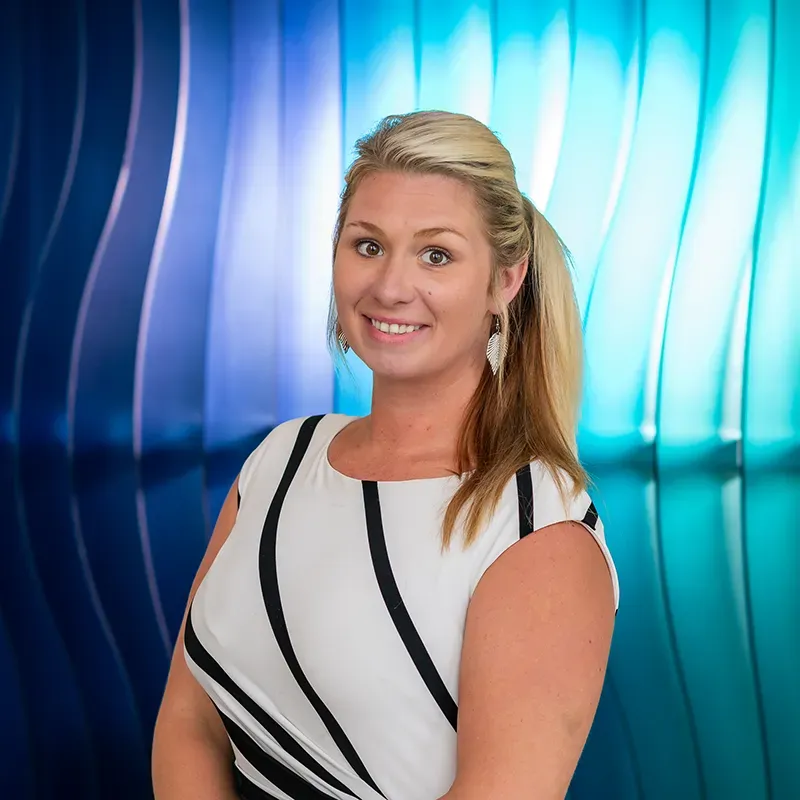 Smiling woman in a white dress with black stripes against a blue abstract background
