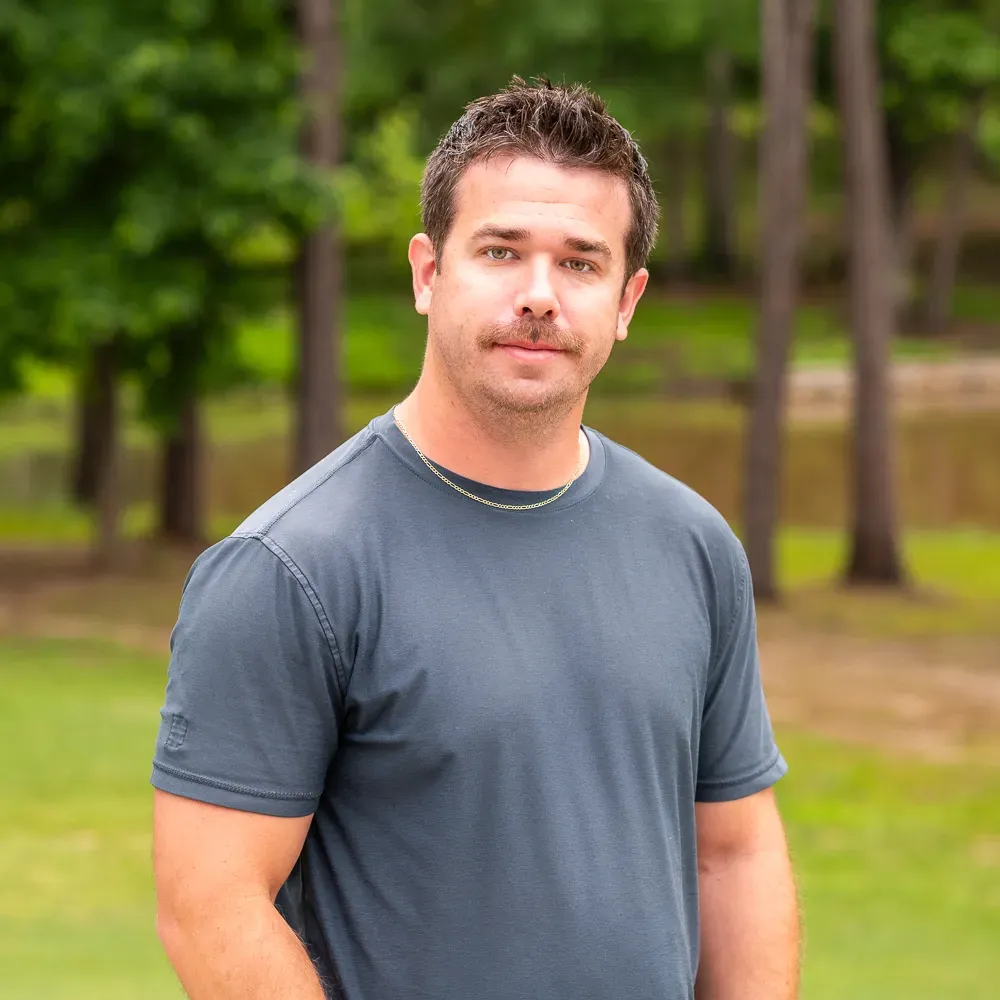 Man in a gray T-shirt standing outdoors