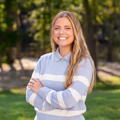 A smiling person with long blonde hair