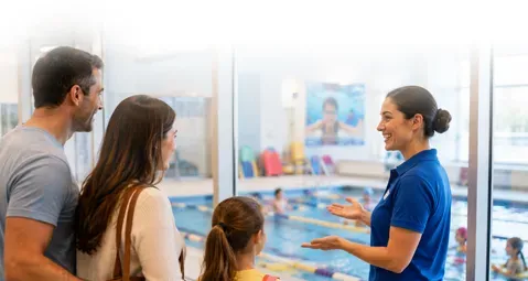 Employee speaking to family at a bright clinic reception desk